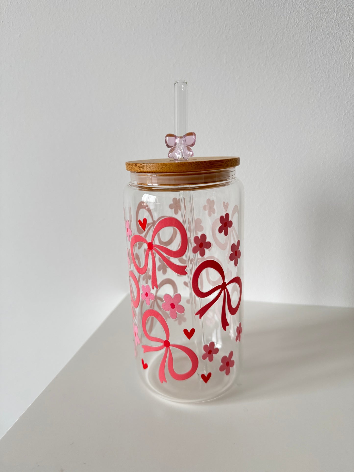 Trinkglas mit Schleifenmuster und Strohhalm